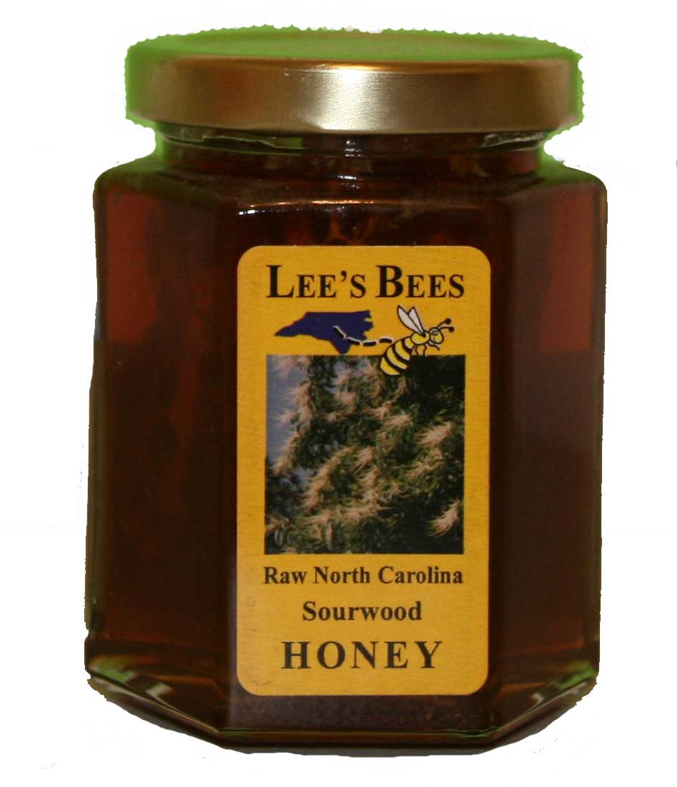 Jar of Lee's Bees Sourwood Honey with Comb, with a piece of honeycomb inside