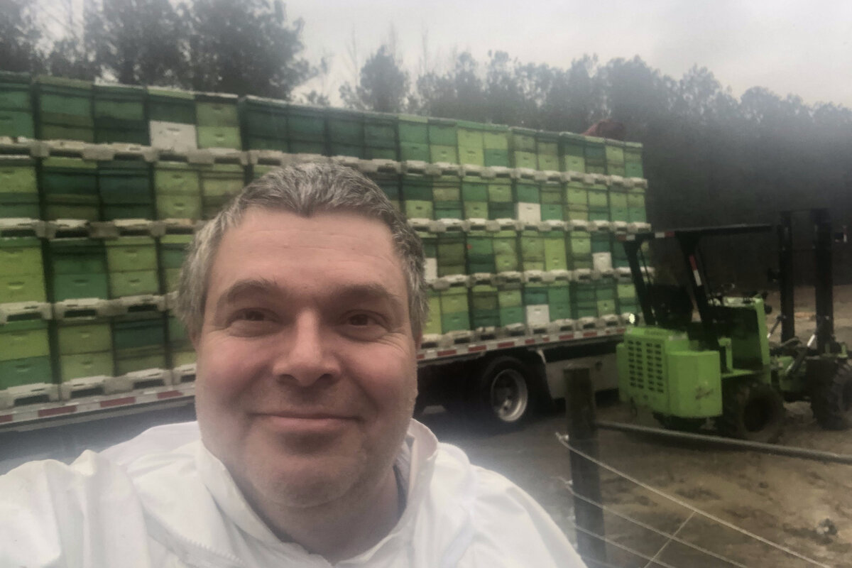 Jeffrey Lee beside a truckload of hives in a California almond orchard