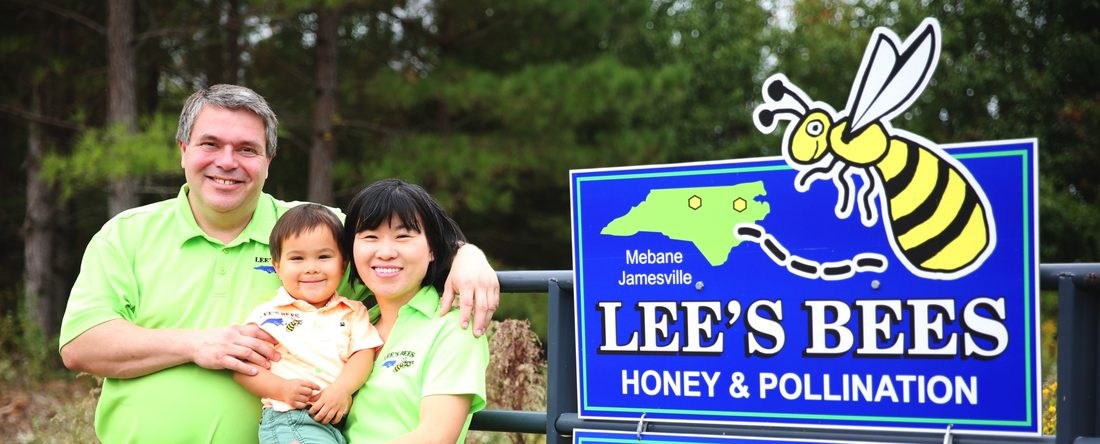 The Lee family beside the Lee's Bees sign
